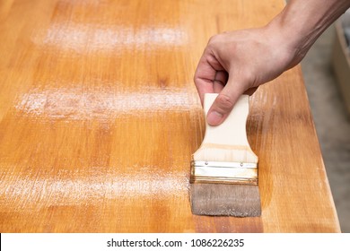 Applying Protective Varnish On A Wooden Furniture