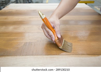 Applying Protective Varnish On A Wooden Furniture