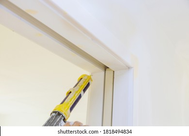 Applying Silicone On Molding Door Trim With Caulking Gun Tool