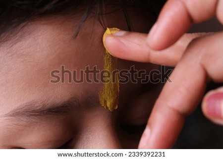 Applying tilak on the forehead