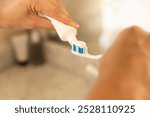 Applying toothpaste on toothbrush, preparing for daily oral hygiene routine. Oral care, dental hygiene, daily routine, clean teeth, brushing, fresh breath