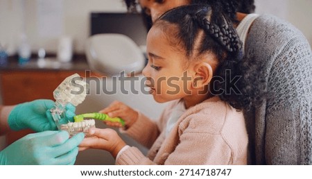 Appointment, brushing teeth or example with dentist, girl and mom in clinic for demonstration. Consulting, dental or mouth model with people in optometry office for advice, checkup or child learning