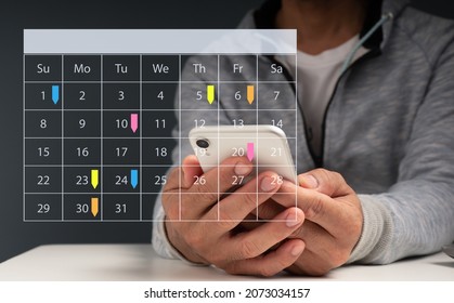 Appointment Reminder for the Calendar and the Organizer's Agenda.Event planners use timetables and agendas to arrange and schedule events.The man is on his phone, taking notes on his virtual calendar - Powered by Shutterstock