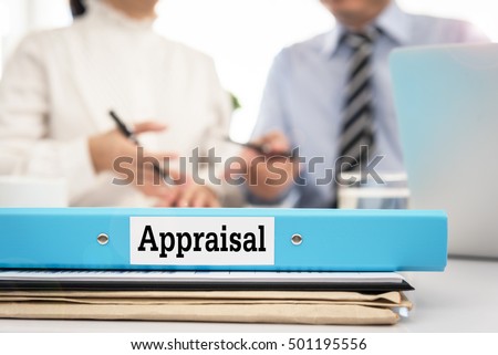 Appraisal documents on desk with manager and board are discuss about property appraisal or the appraisal process and performance ratings.