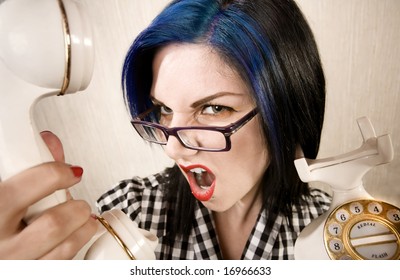Apprehensive young woman yelling into a vintage phone