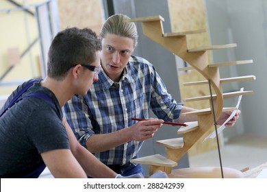 Apprentice With Adult In Carpentry School Working On Wood