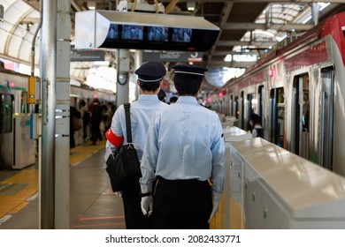 An apprentice conductor with a red armband to check before boarding on the platform of the station