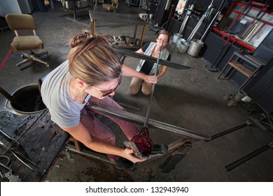 Apprentice and glass artisan creating fine art glass - Powered by Shutterstock