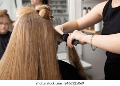 Apprentice hairdresser straightening woman long hair, hairdressing hairstyle styling, beauty salon parlour parlor, formal occasion graduation wedding engagement prom upstyle - Powered by Shutterstock