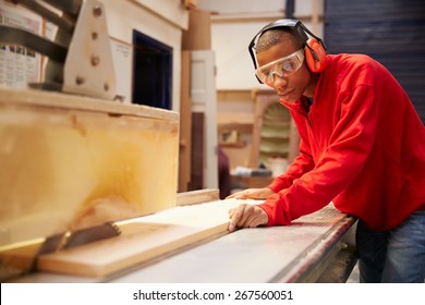 Apprentice Using Circular Saw In Carpentry Workshop