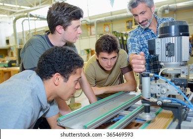 Apprentices learning to use machine