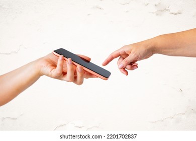 Appropriation of famous Michelangelo's painting The Creation of Adam with God's finger reaching to the screen of mobile phone - Shutterstock ID 2201702837