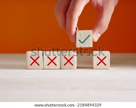 Approval or choosing the right option for business startup concept. Hand puts wooden cube with right icon next to the cubes with wrong icons.