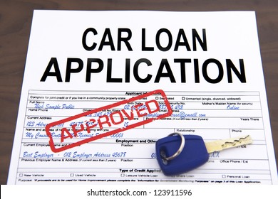 Approved car loan application form and key on desktop