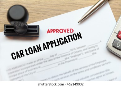 Approved Car Loan Application Form Lay Down On Wooden Desk With Rubber Stamp And Calculator.