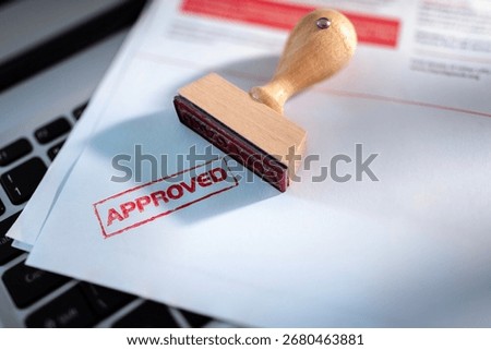 Approved stamp on application form or business agreement document on laptop in office
