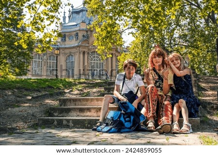 appy schoolchildren sitting on the steps on a sunny day
