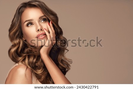 appy and surprised girl  smiling  looking to the side presenting  your product . Beautiful curly hair woman amazed ,   with red nails manicure. Expressive facial expressions. Pin up