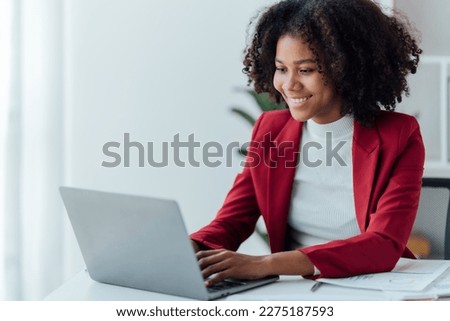 appy young businesswoman African American siting on the chiar cheerful demeanor raise holding coffee cup smiling looking laptop screen.Making opportunities female working successful in the office.