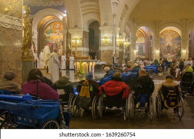 Apr 28. 2014 Lourdes France Bishop prays for the healing of sick people in wheelchairs at Rosary Basilica.