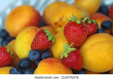 Apricots, strawberries and blueberries on a plate