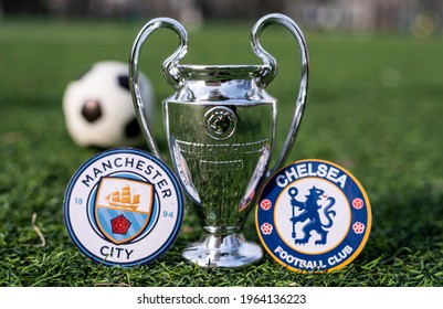 April 16, 2021 Moscow, Russia. The UEFA Champions League Cup and the emblems of the Manchester City F. C. and Chelsea F. C. London football clubs on the green grass of the lawn.