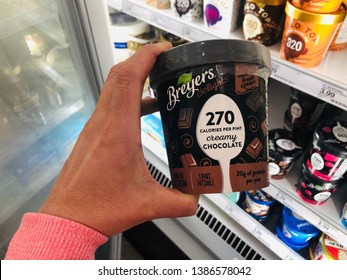 April 19, 2019 - Maple Grove, MN: Female Shopper's Hand Holds A Pint Of Breyer's Delights Low Calorie, High Protein Diet Ice Cream While Grocery Shopping