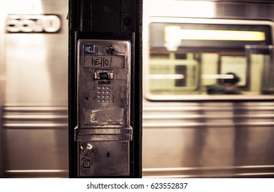 April 2, 2017.  New York City, New York.  Subway Car Flies By An Old Pay Phone. 