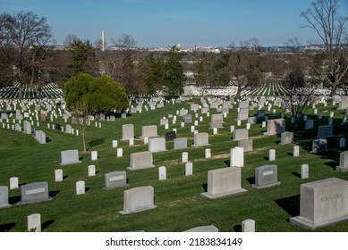 April 2, 2022, Arlington, VA, Arlington National Cemetery, Rows Of Tombstones Headstones With The Washington Monument And US Capitol Building In The Background