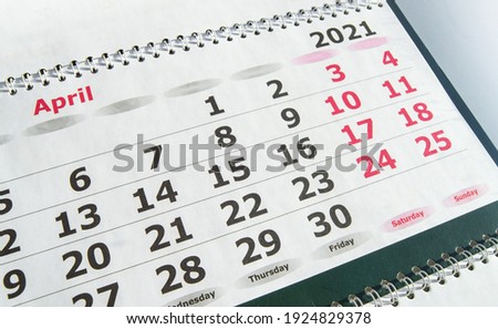 April 2021 paper calendar planner with spiral, close-up.