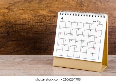 The April 2022 desk calendar on wooden background.
