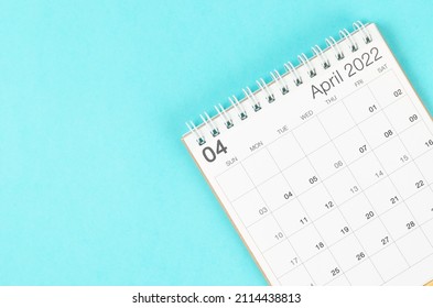 The April 2022 desk calendar on blue background with empty space.