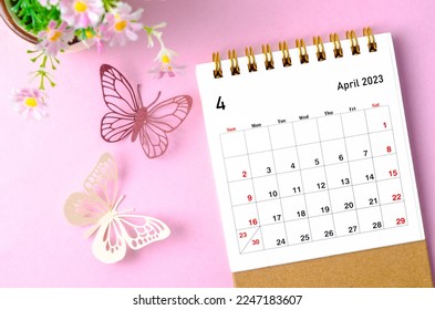 April 2023 desk calendar for the organizer to plan and reminder and paer butterfly on pink colour background.