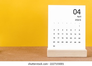 April 2023 Monthly calendar for 2023 year on yellow table.