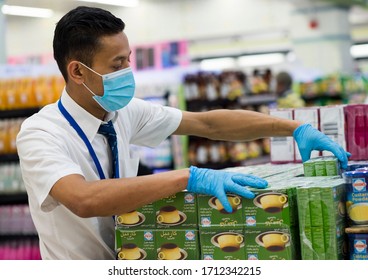 APRIL 23, 2020-DOHA,QATAR: The Hypermarket Employee Wearing Face Mask Due To The Covid-19 Coronavirus Pandemic Is Staking Ramadan Food Items  Boxes In Store ahead of The Holy Month Of Ramadan In Doha