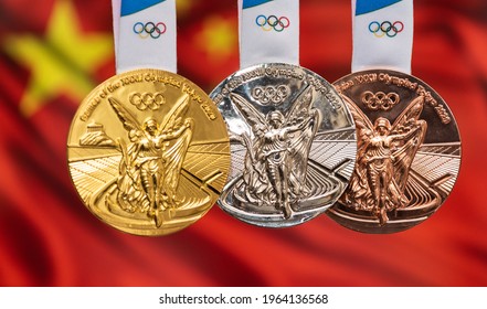 April 25, 2021 Tokyo, Japan. Gold, silver and bronze medals of the XXXII Summer Olympic Games 2020 in Tokyo on the background of the flag of China.