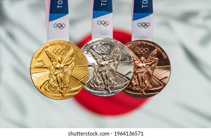 April 25, 2021 Tokyo, Japan. Gold, silver and bronze medals of the XXXII Summer Olympic Games 2020 in Tokyo on the background of the flag of Japan.