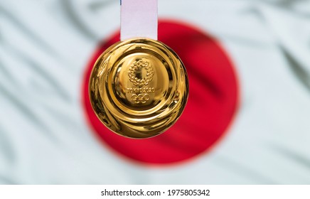 April 25, 2021 Tokyo, Japan. Gold medal of the XXXII Summer Olympic Games 2020 in Tokyo on the background of the flag of Japan.