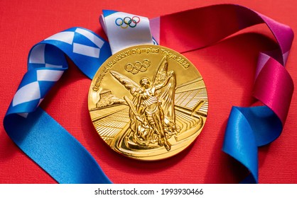 April 25, 2021 Tokyo, Japan. Gold Medal Of The XXXII Summer Olympic Games In Tokyo On A Red Background.