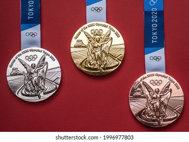 April 25, 2021 Tokyo, Japan. Gold, silver and bronze medals of the XXXII Summer Olympic Games in Tokyo on a red background.