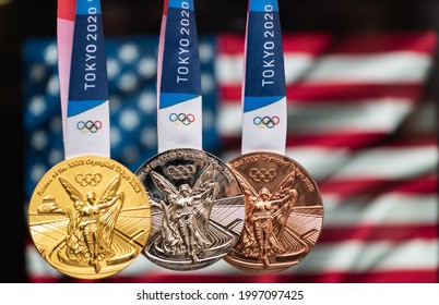 April 25, 2021 Tokyo, Japan. Gold, Silver And Bronze Medals Of The XXXII Summer Olympic Games 2020 In Tokyo On The Background Of The US Flag.