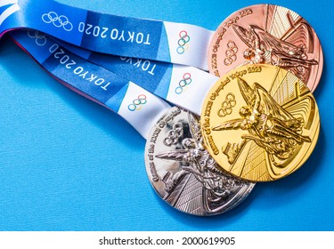 April 25, 2021 Tokyo, Japan. Gold, Silver And Bronze Medals Of The XXXII Summer Olympic Games In Tokyo On A Blue Background.