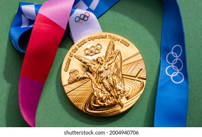 April 25, 2021 Tokyo, Japan. Gold Medal Of The XXXII Summer Olympic Games In Tokyo On A Green Background.