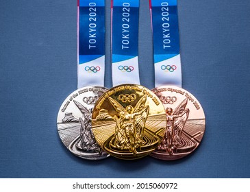 April 25, 2021 Tokyo, Japan. Gold, silver and bronze medals of the XXXII Summer Olympic Games in Tokyo on a dark blue background.