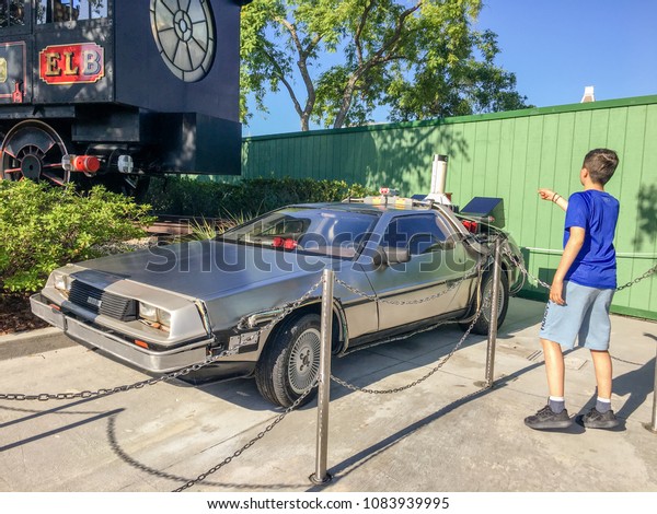 APRIL 29, 2018 - ORLANDO, FLORDIA: ELEVEN YEAR\
OLD BOY IN FRONT OF OFFICIAL \'BACK TO THE FUTURE\' DELOREAN TIME\
TRAVEL CAR AT UNIVERSAL STUDIOS. \
