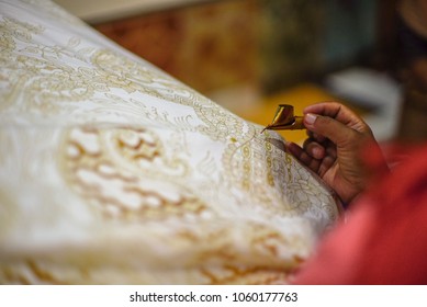 April 3 2018, Surakarta Indonesia : Close Up Hand To Make Batik Tulis On The Fabric With Canting With Bokeh Background