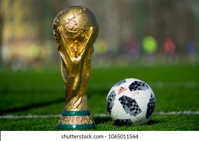 April 9, 2018 Moscow, Russia Trophy of the FIFA World Cup and official ball of FIFA World Cup 2018 Adidas Telstar 18 on the green grass of the football field. 