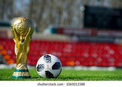 April 9, 2018 Moscow, Russia Trophy of the FIFA World Cup and official ball of FIFA World Cup 2018 Adidas Telstar 18 on the green grass of the football field. 