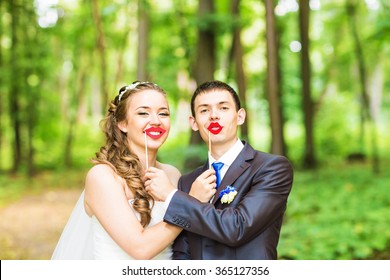 April Fools' Day. Wedding Couple Posing With Stick Lips, Mask. 