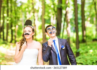 April Fools' Day. Wedding Couple Posing With Stick Lips, Mask. 